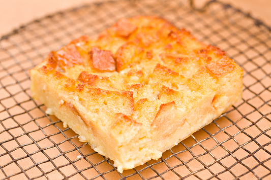 Coconut jam bread pudding golden and bubbling in a baking dish made with Yeo's Coconut Jam bananas and vanilla custard sauce
