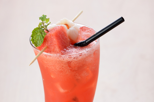 Lychee watermelon cocktail in a glass with fresh mint, lychee, and watermelon garnish made with Yeo's Lychee Drink