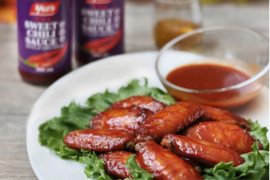 Crispy oven-baked sweet chili chicken wings glazed with Yeo's Sweet Chili Sauce and garnished with chopped green onions on a white plate