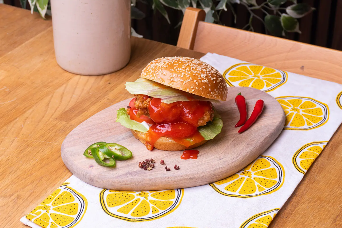 Spicy crispy chicken sandwich with Yeo's Hot Chili Sauce drizzle on a toasted brioche bun