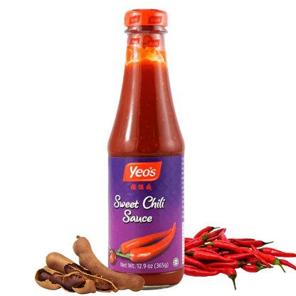 Yeo’s Sweet Chili Sauce bottle on white background with tamarind pods and red chili peppers, sweet and mild Asian chili dipping sauce.